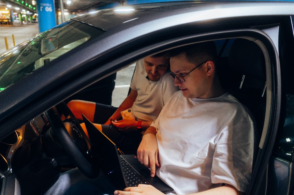 Специалисты проводят компьютерную диагностику автомобиля с ноутбуком в салоне